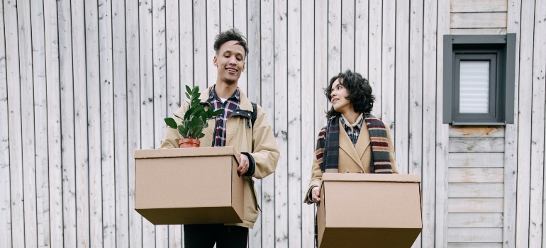 couple holding moving boxes