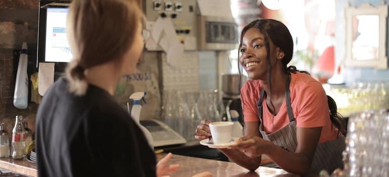 Female barista smiling and serving coffee