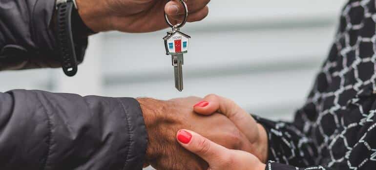 A person giving house keys to another person