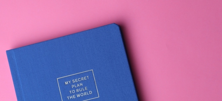 Picture of a blue book on a pink surface