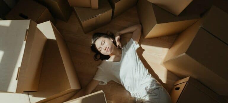 Woman on the floor surrounded by moving boxes