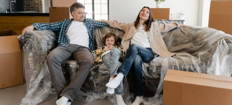 A family of three sitting on a new couch