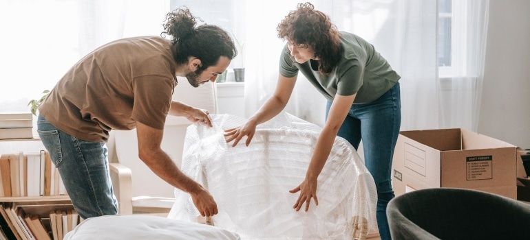 Picture of a couple using bubble wrap to pack