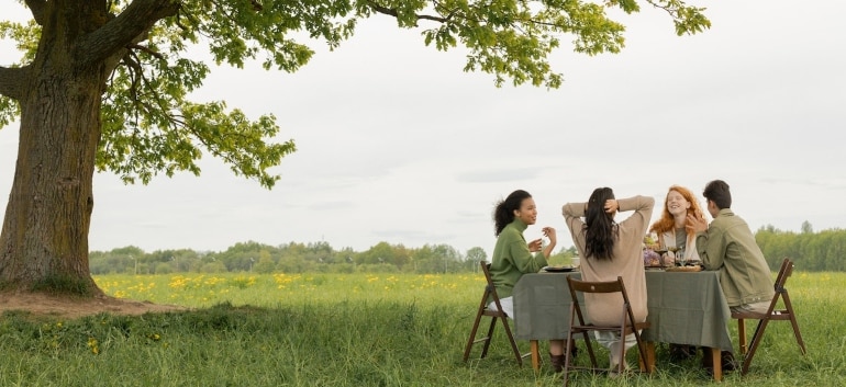 PIcture of people siting around a table under a tree and talking about choosing the right California city to move to
