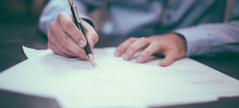 Picture of a person signing a contract