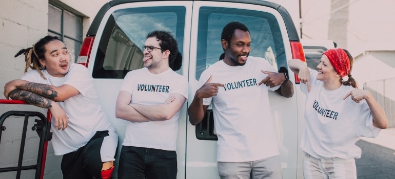 four friends in white t-shirts volunteering after moving out of state